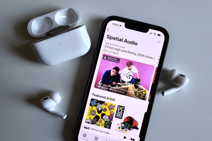 مجموعة الصوت المكاني من Apple Music تظهر على iPhone 14، بجوار Apple AirPods Pro.