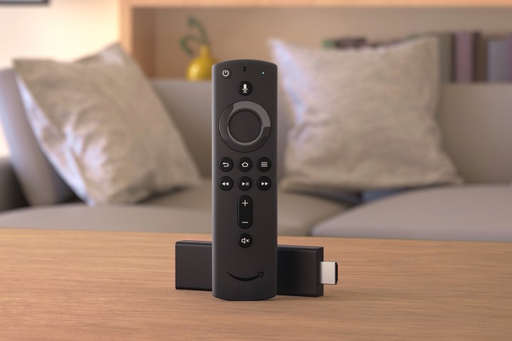 Amazon Fire TV Stick وجهاز التحكم عن بعد يجلسان على طاولة غرفة المعيشة.