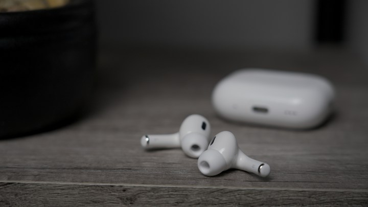 سماعات Apple AirPods Pro 2 مزودة بسماعات USB-C وMagSafe على طاولة مع علبة في الخلفية.