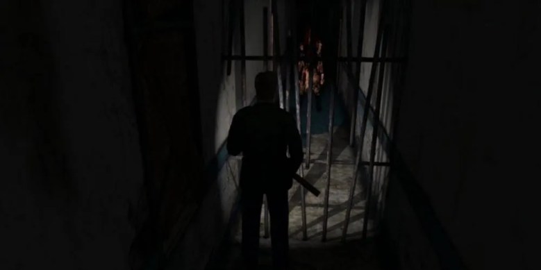 James looks at Pyramid Head through bars in Silent Hill 2.