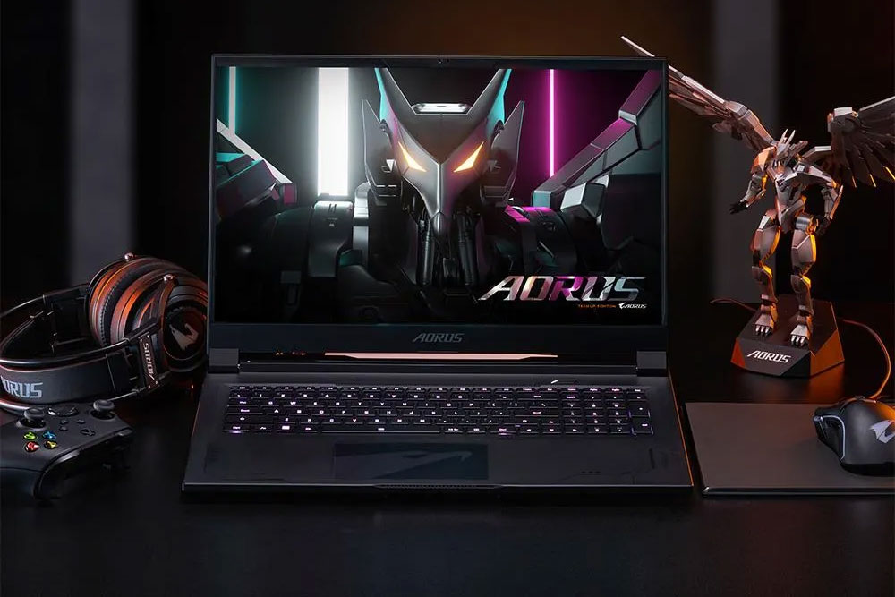 كمبيوتر محمول للألعاب من Aorus على مكتب للألعاب مع ملحقات للألعاب