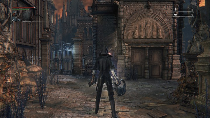 الشخصية الرئيسية في لعبة Bloodborne تقف أمام أحد المباني.