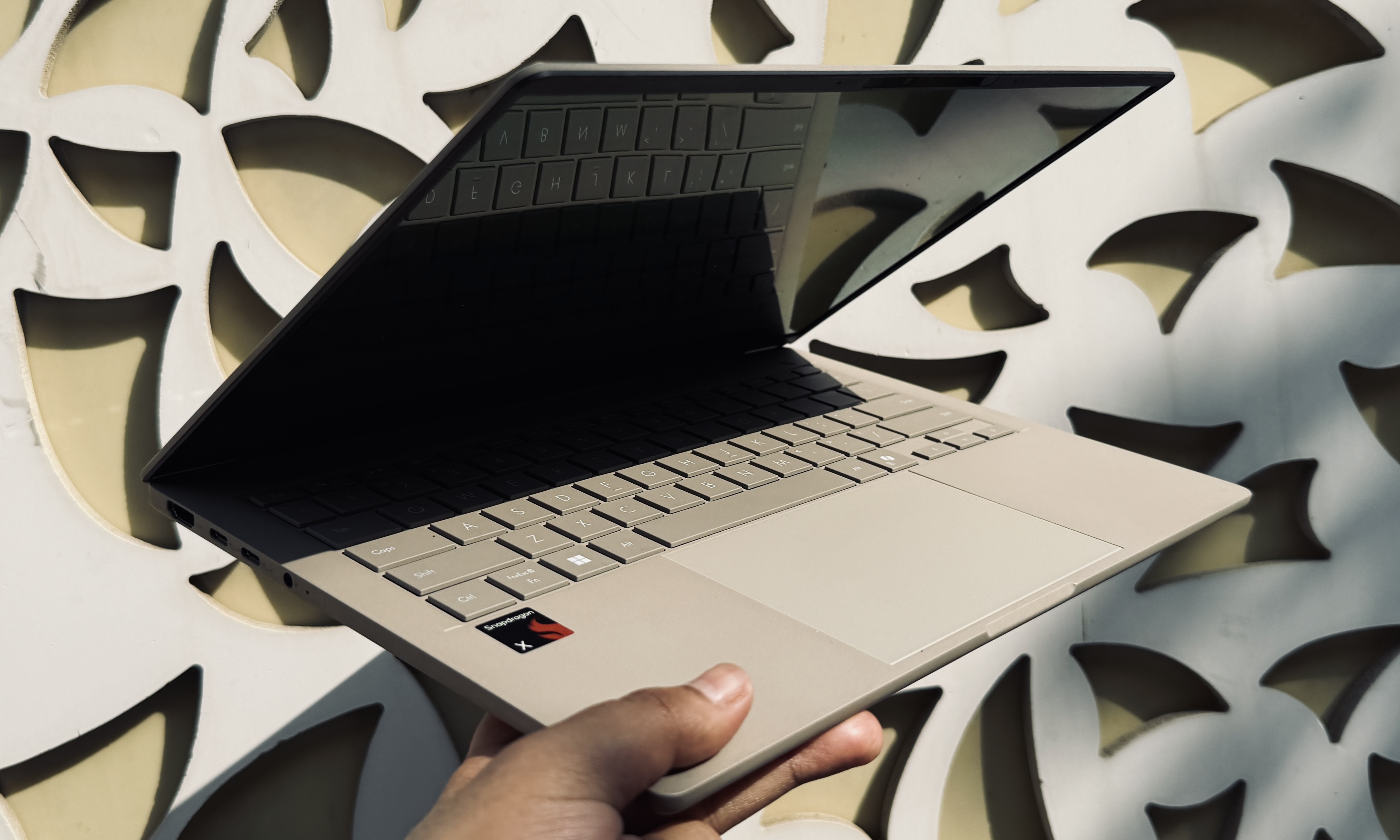الشخص الذي يحمل جهاز الكمبيوتر المحمول Asus Zenbook A14.