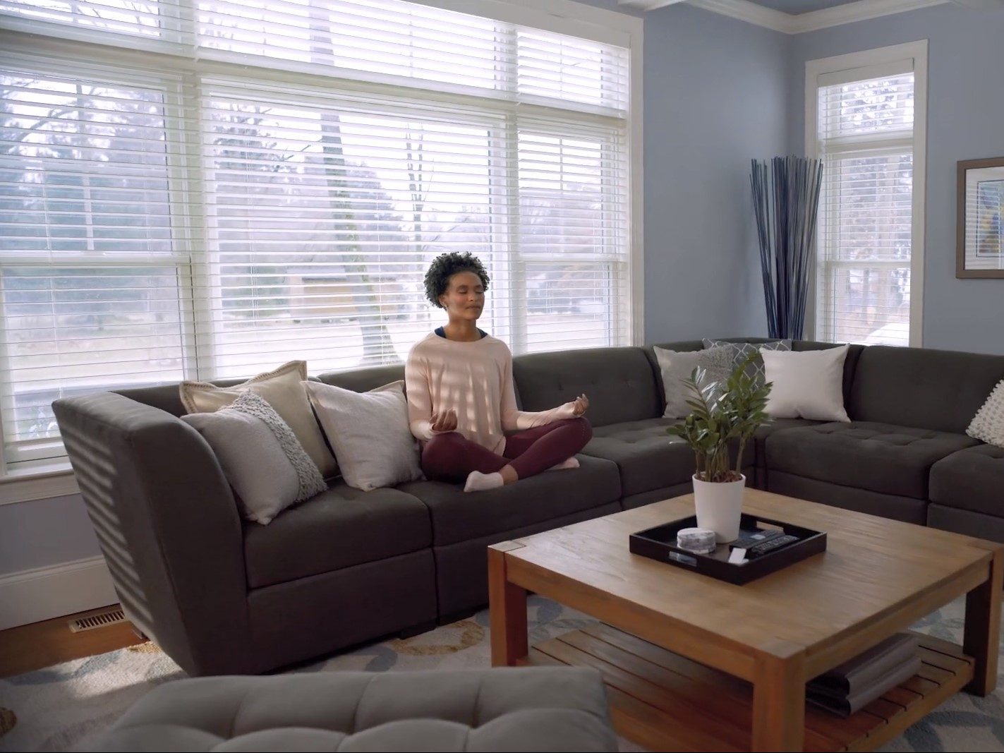 امرأة تتأمل في غرفة مع سيرينا من قبل Lutron Smart Strains / Smart Shades.