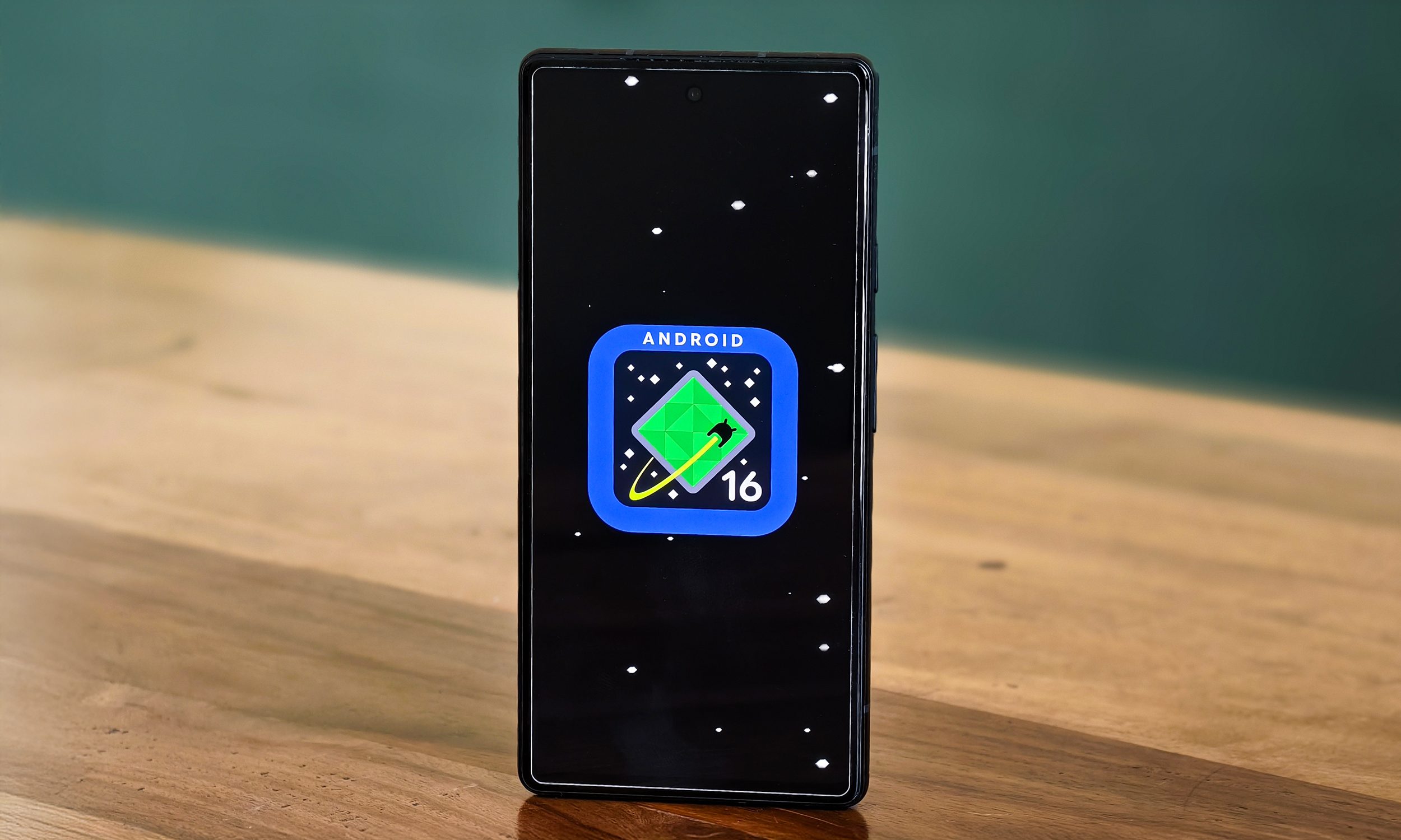Android 16 Logo On Google Pixel 6A يقف على طاولة.
