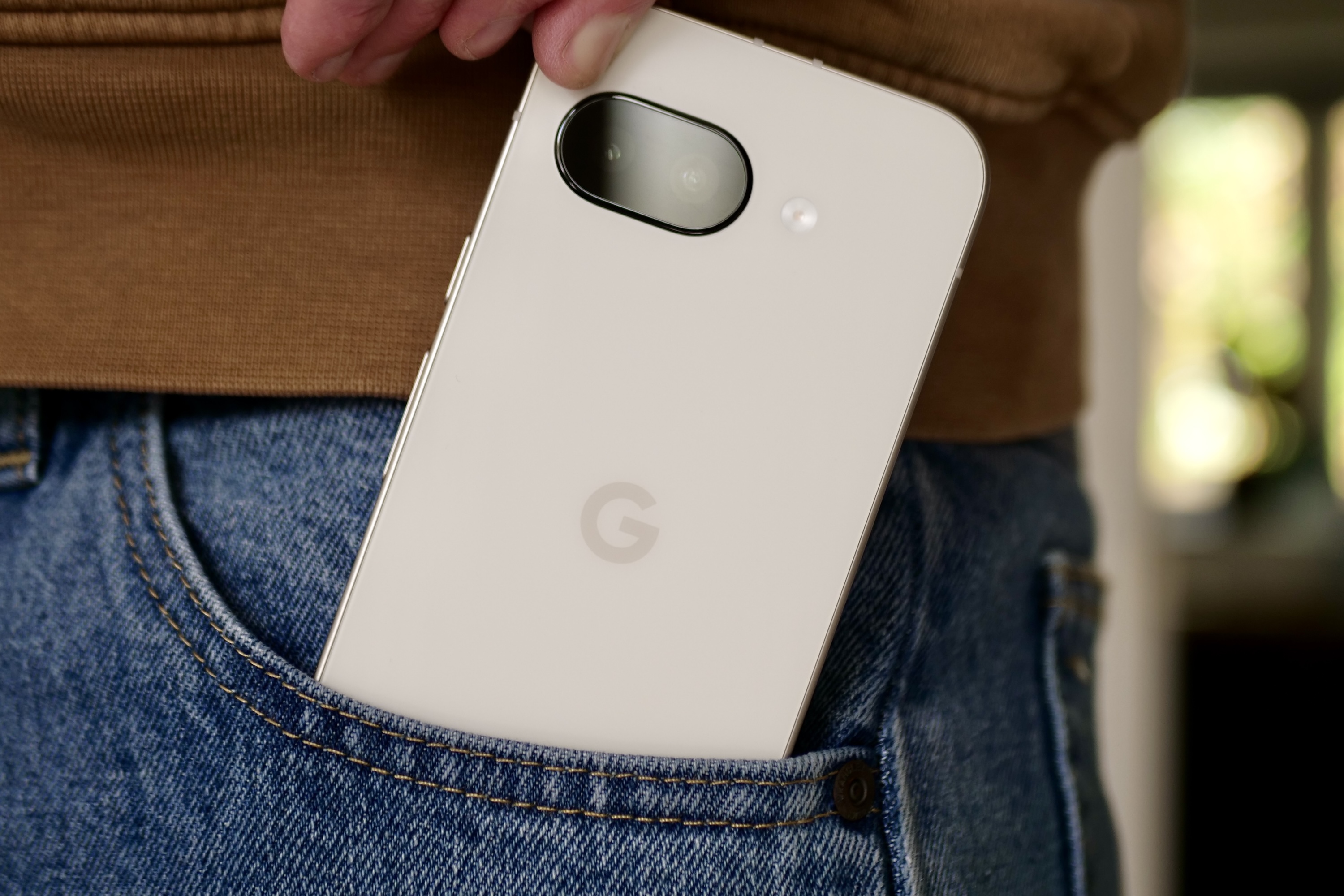 شخص يأخذ Google Pixel 9a من الجيب.
