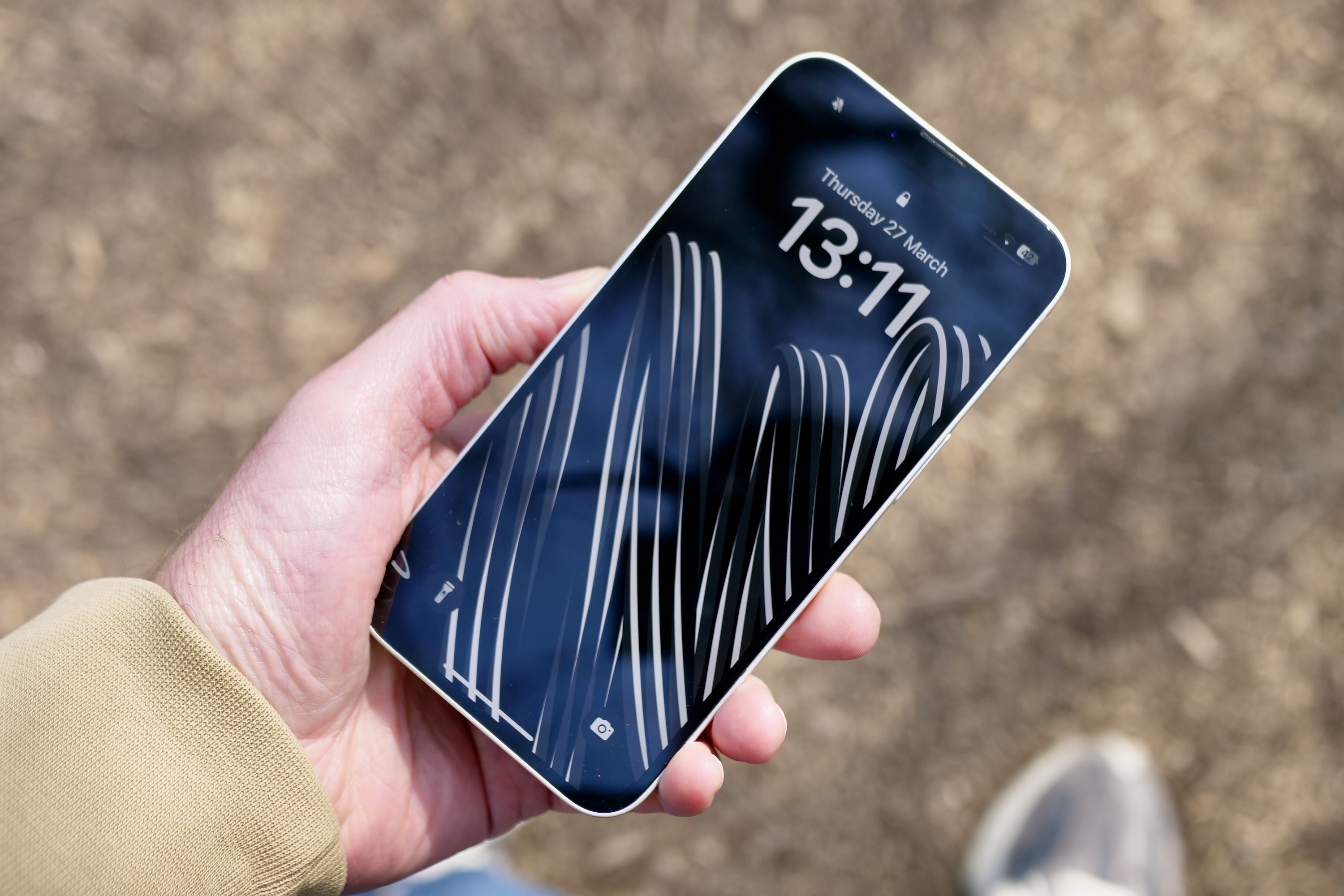 الشخص الذي يحمل Apple iPhone 16e يعرض الشاشة.
