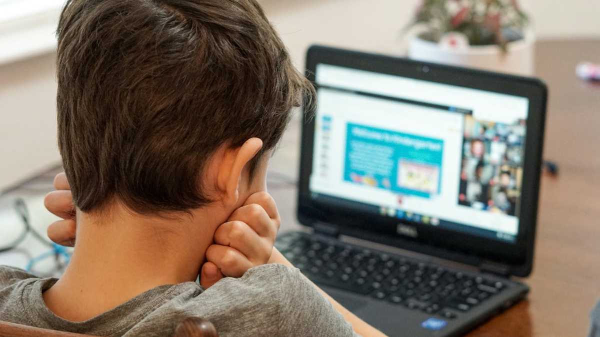 فتى طالب طفل ليس سعيدًا باستخدام جهاز كمبيوتر محمول Chromebook للمدرسة