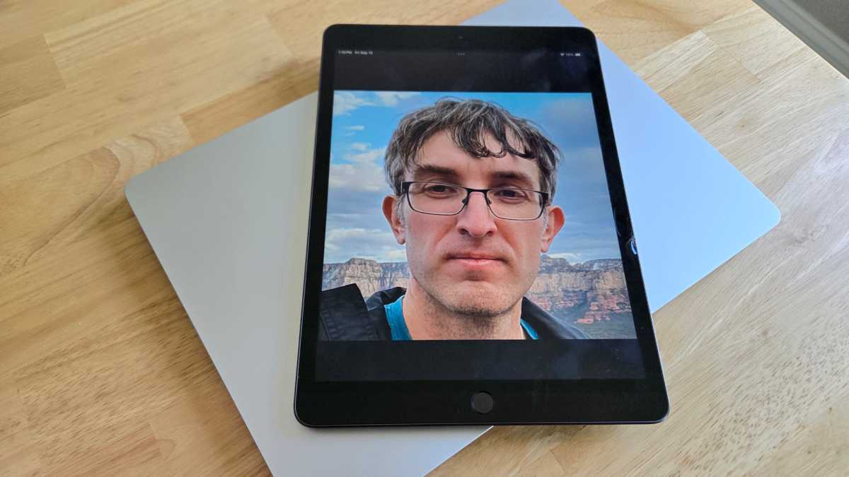 iPad مع صورة وجه كريس هوفمان على جهاز Surface Laptop